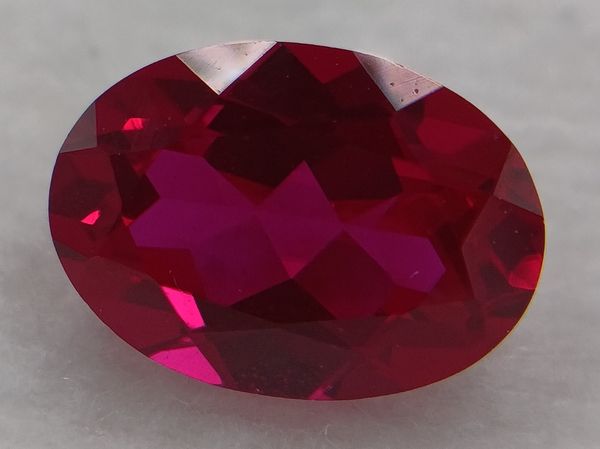 Rubis synthétique rouge ovale 7x5 mm – 0.90 ct (Verneuil) sur fond blanc 