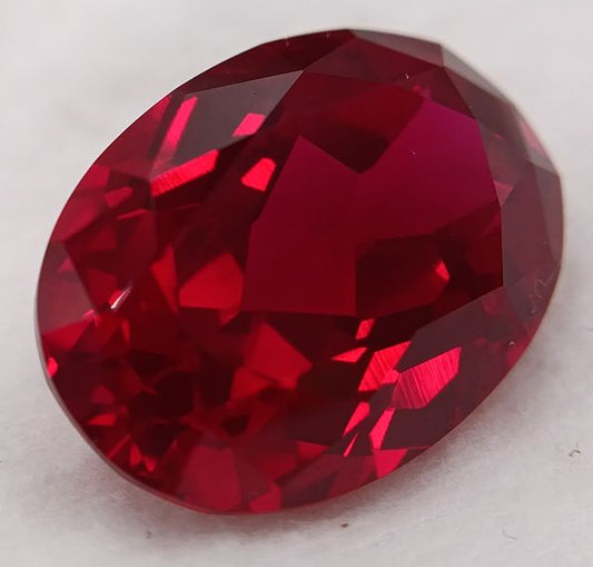 Rubis synthétique rouge ovale 8x6 mm – 1.35 ct (Verneuil) sur fond blanc