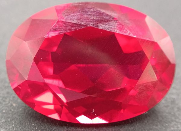 Rubis verneuil ovale a facettes 20x15 mm 25.30 carats sur fond noir 
